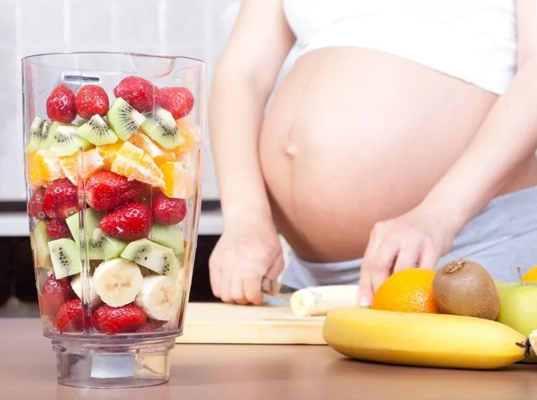 Donna gravida prepara frullato
